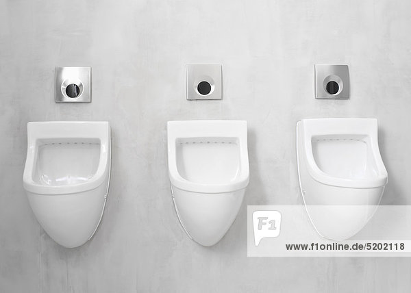 Drei Pissoir-Becken in Toilette