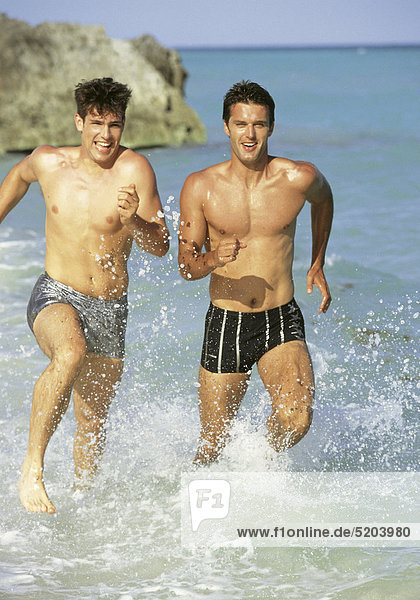 Zwei Männer laufen durchs Wasser