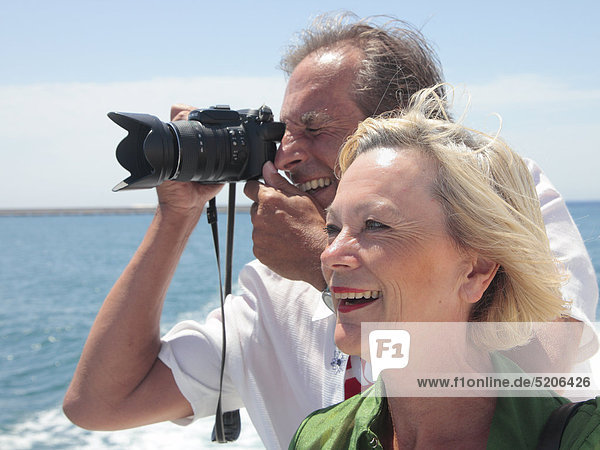 Älteres Paar fährt auf Schiff  er fotografiert
