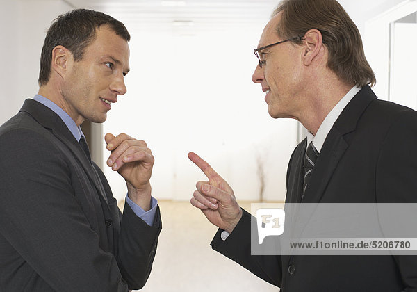 Zwei Männer diskutieren im Büro am Gang