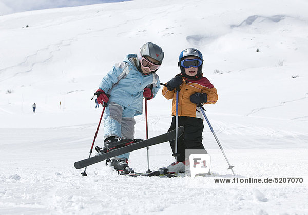 Zwei kleine Kinder beim Skifahren
