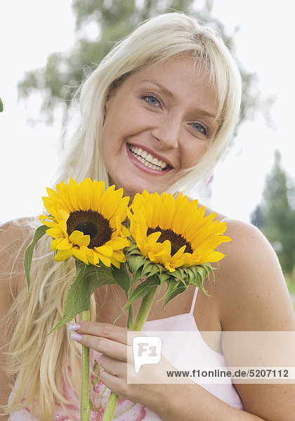 Frau  blond  mit zwei Sonnenblumen  Halbporträt