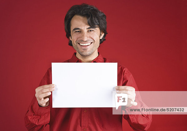 Mann hält leeres Blatt Papier vor sich  roter Hgr.