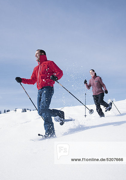 Paar beim Schneeschuhwandern  laufen bergab