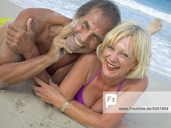 Älteres Paar liegt am Strand  Halbporträt