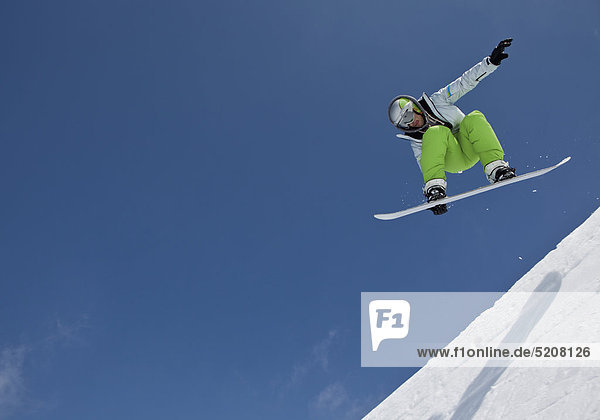Snowboarder springt in Halfpipe