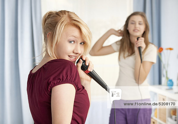 Zwei Mädchen singen in Mikrophon