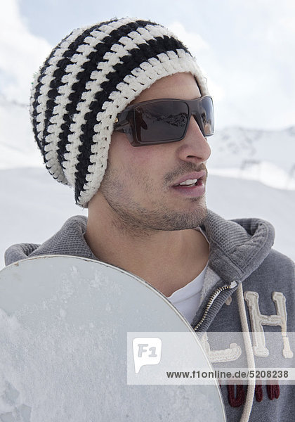 Junger Mann mit Snowboard  Portrait