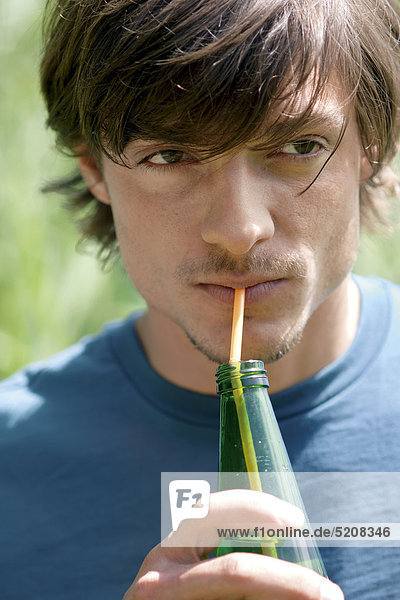 Junger Mann mit Getränkeflasche  Porträt
