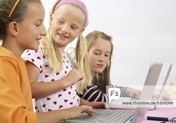 Drei Mädchen arbeiten mit Laptop