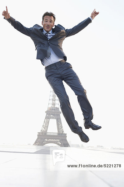 Businessman jumping with the Eiffel Tower in the background  Paris  Ile-de-France  France