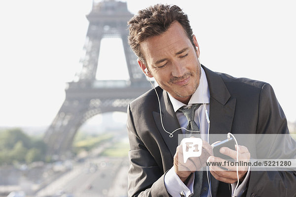 Geschäftsmann mit Handy und Eiffelturm im Hintergrund  Paris  Ile-de-France  Frankreich