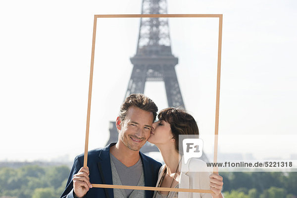 Paar umrahmt ihren Traumurlaub mit dem Eiffelturm im Hintergrund  Paris  Ile-de-France  Frankreich