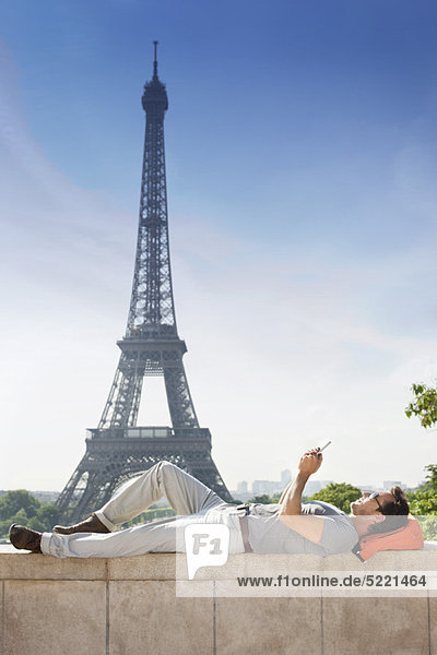 Mann auf einer Steinmauer mit dem Eiffelturm im Hintergrund  Paris  Ile-de-France  Frankreich