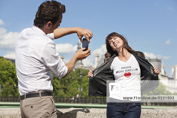 Man taking a picture of a woman with a mobile phone  Seine River  Paris  Ile-de-France  France