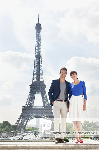 Paar steht zusammen mit dem Eiffelturm im Hintergrund  Paris  Ile-de-France  Frankreich