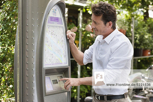 Mann auf der Suche nach einer Karte in einem Fahrkartenautomaten  Paris  Ile-de-France  Frankreich