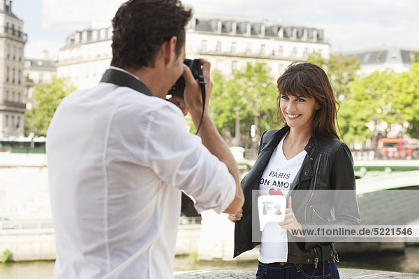 Man taking a picture of a woman with a camera  Seine River  Paris  Ile-de-France  France