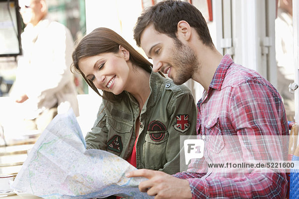 Ein Paar sitzt in einem Straßencafé und liest eine Karte  Paris  Ile-de-France  Frankreich