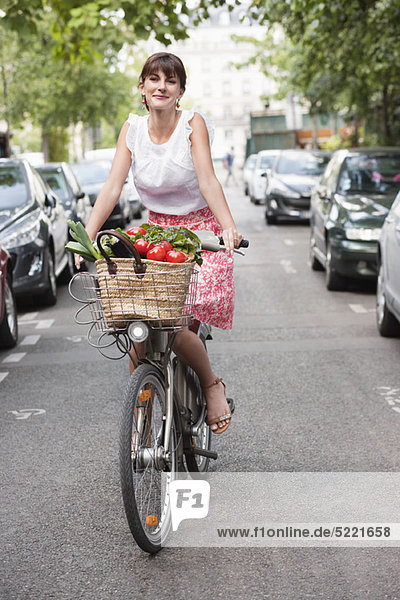 Woman carrying vegetables on a bicycle  Paris  Ile-de-France  France