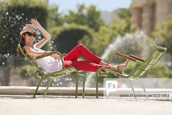 Frau auf einem Stuhl in der Nähe eines Teiches  Bassin achteckig  Jardin des Tuileries  Paris  Ile-de-France  Frankreich