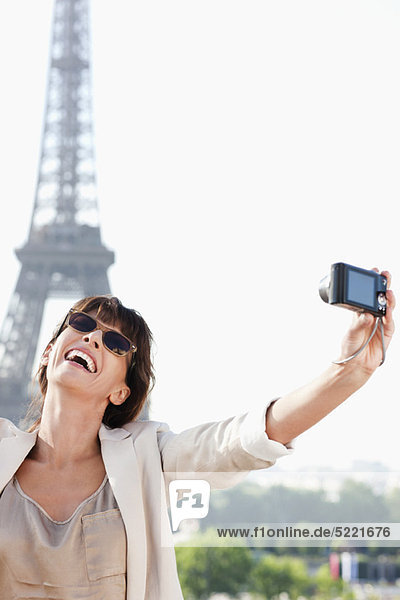 Frau beim Fotografieren mit dem Eiffelturm im Hintergrund  Paris  Ile-de-France  Frankreich