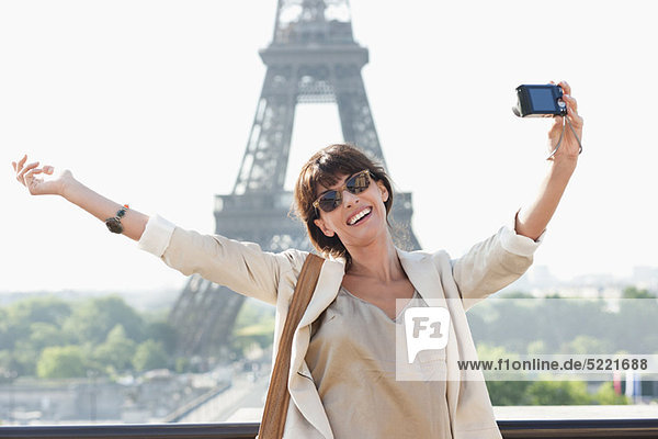 Woman taking a picture of herself with the Eiffel Tower in the background  Paris  Ile-de-France  France