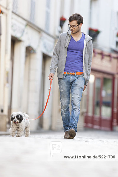 Mann mit einem Hund an der Leine auf der Straße  Paris  Ile-de-France  Frankreich