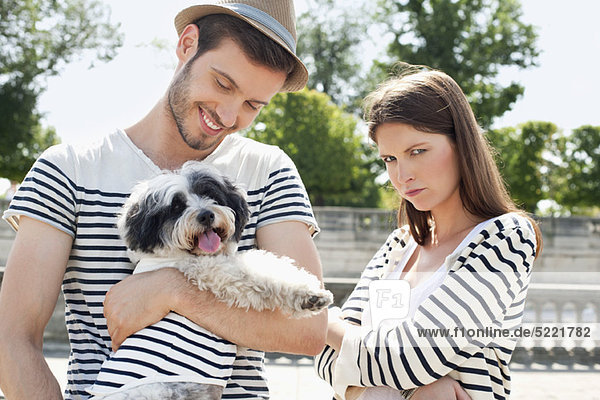Man carrying a puppy and smiling with a woman looking sad  Paris  Ile-de-France  France