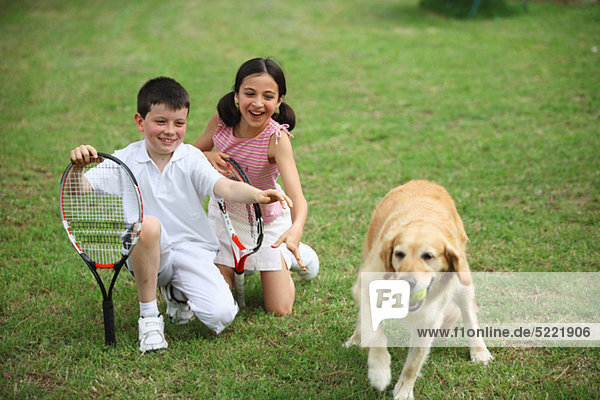Junge Boy und Girl Playing With Labrador Hund