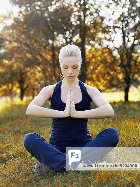 Eine Frau  die Yoga in der Natur praktiziert.