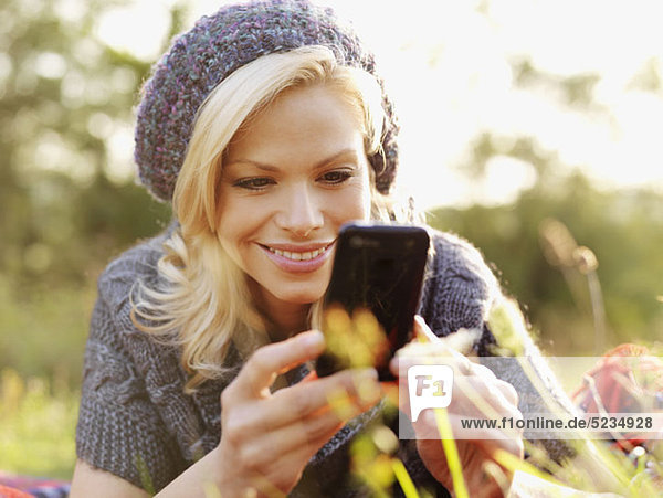A smiling woman looking at her smart phone