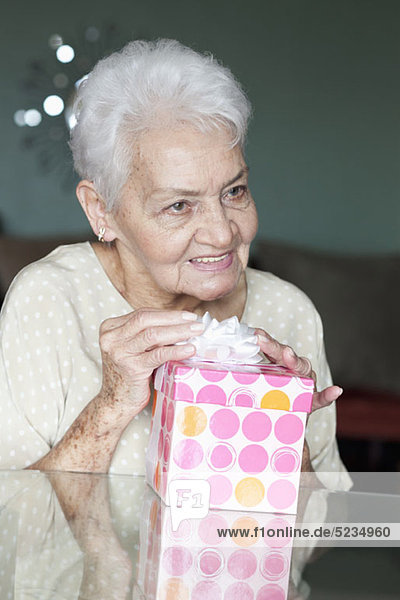 Porträt einer älteren Frau mit einem Geschenk