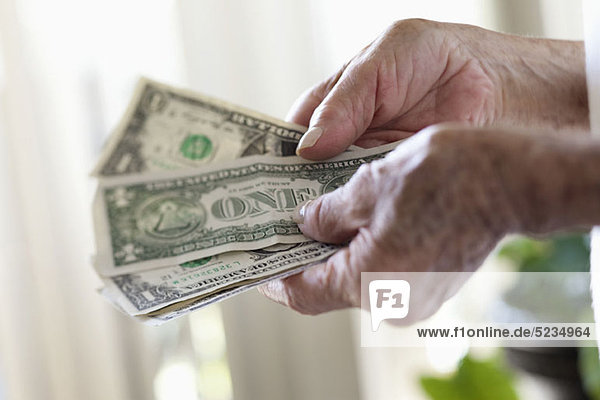Detail einer älteren Frau mit US-Banknoten