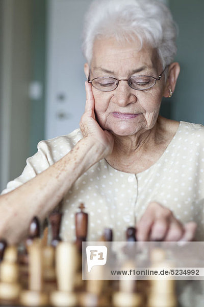 Eine ältere Frau beim Schachspielen