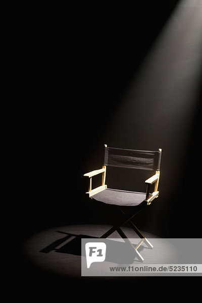 A spot lit directors chair