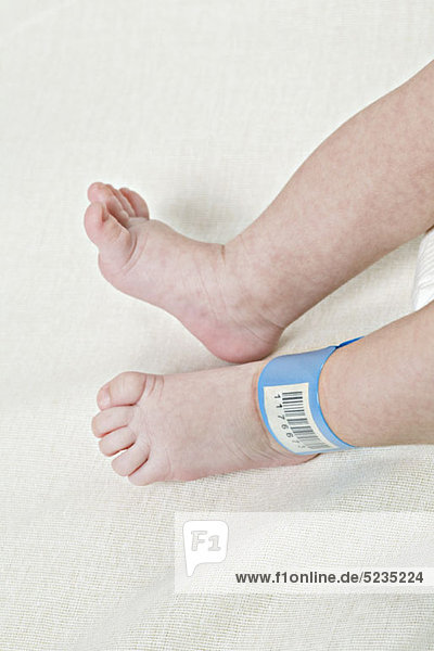Ein Krankenhaus-Ausweis-Armband am Knöchel eines Babys.