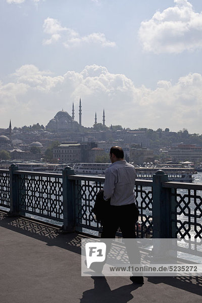 Ein Geschäftsmann  der über die Galata-Brücke geht  Istanbul  Türkei