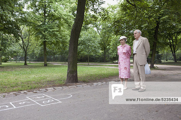 Seniorenpaar erwägt Hopscotch im Park