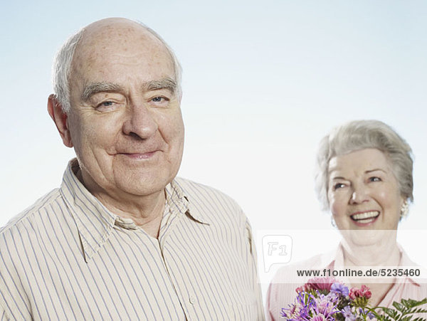 Senior man looks pleased that she likes the flowers