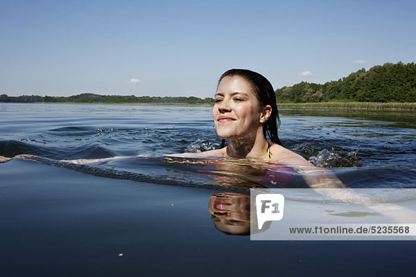 Mädchen schwimmt fröhlich im See