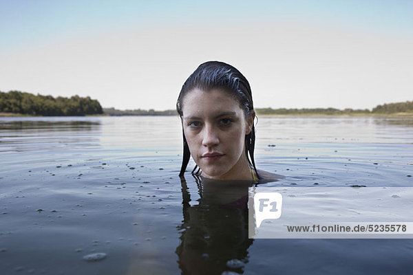Profile of girl with head above water looking at camera
