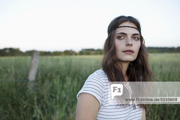 Profil des Mädchens mit Haarband im Feld stehend zur Seite schauend