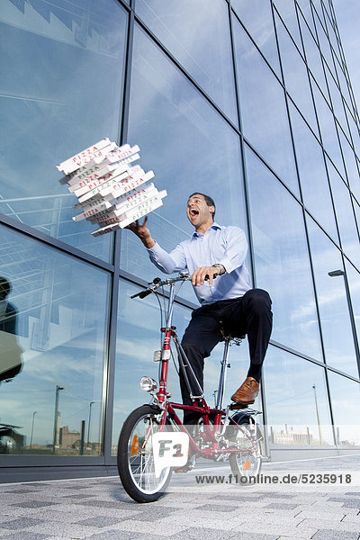 Mann mit Pizzakartons auf dem Fahrrad