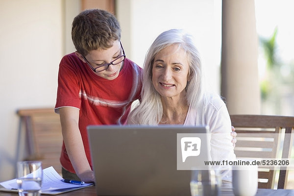 Grandmother and grandson using laptop