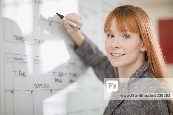 Geschäftsfrau schreibt im Kalender