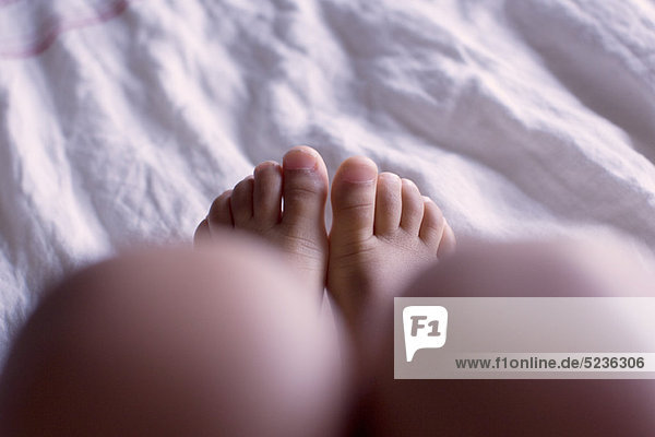 Fuß des Kindes auf dem Bett  Unterteil