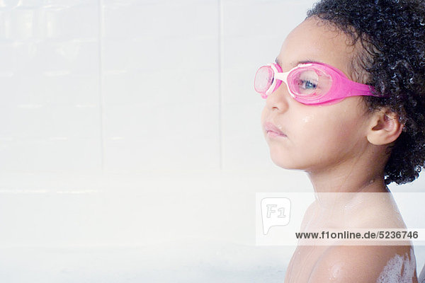 Kleines Mädchen mit Schwimmbrille im Bad