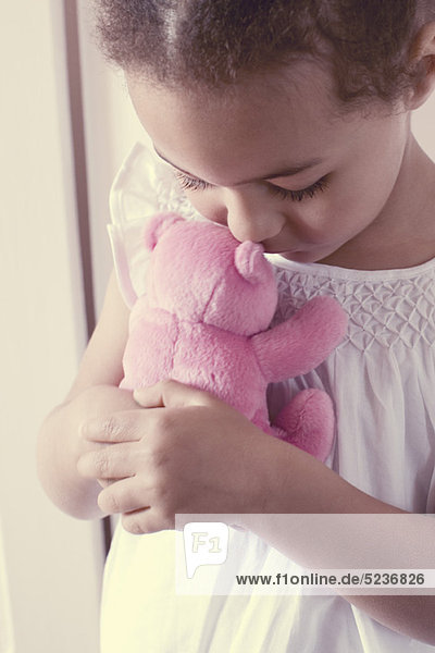 Kleines Mädchen umarmt Teddybär