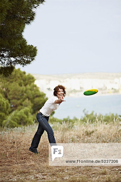 Außenaufnahme  Frau  werfen  Frisbee  freie Natur